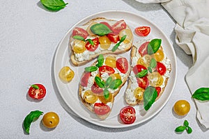 Fresh bread sandwiches with tomato cherry, cream cheese and basil leaves. Morning breakfast concept