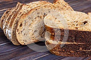 Fresh bread slices on cutting board against white wooden background