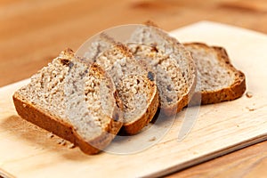 Fresh bread slices on rustic wooden board