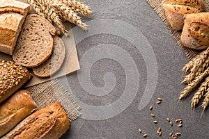 Bread background with wheat, aromatic crispbread with grains, copy space, top view. Brown and white whole grain loaves still life