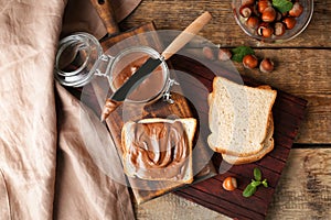 Fresh bread with tasty chocolate paste on table