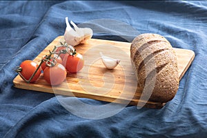 Fresh bread, tomato, garlic on a cutting board