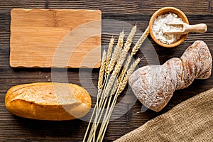 Fresh bread with wheat flour in bakery shop on wooden desk background top view space for text