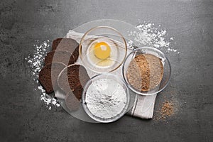 Fresh breadcrumbs, flour and egg on grey table, flat lay