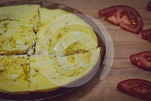 Fresh Breakfast on a plate. Fried in butter omelet with eggs and milk. Further away are tomatoes, cut into slices