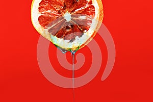 Fresh bright grapefruit with water drops on red background, copy space.