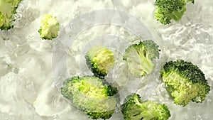 Fresh broccoli florets fall into water, signifying the joy of cooking with natural ingredients. The scene taps into