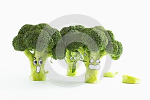 Fresh broccoli with scared cartoon style faces on white background