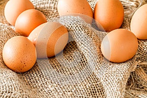 Fresh brown cage free eggs on burlap.