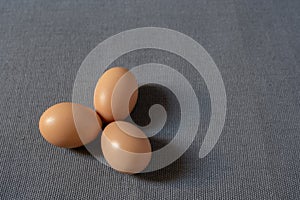 Fresh brown chicken eggs on grey background