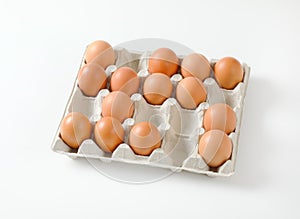 Fresh brown eggs in paper carton