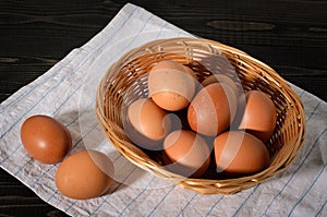 Fresh brown eggs on rustic, wooden, black, dark background