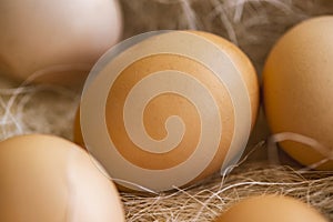 Fresh brown eggs and some straw in a wooden crate