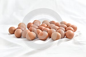 Fresh brown Eggs on white fabric background