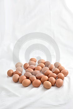 Fresh brown Eggs on white fabric background