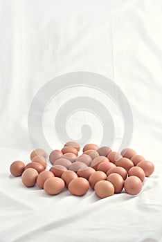 Fresh brown Eggs on white fabric background