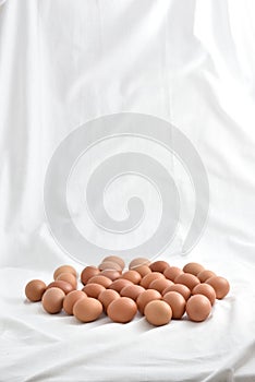 Fresh brown Eggs on white fabric background