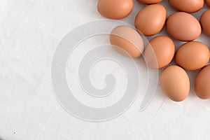 Fresh brown Eggs on white fabric background