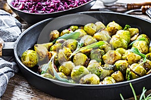 Fresh brussels sprouts in black iron pan on grey table