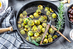 Fresh brussels sprouts in black iron pan on grey table