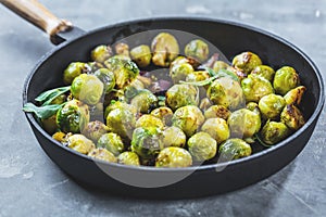 Fresh brussels sprouts in black iron pan on grey table