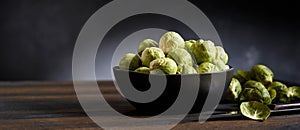 Fresh Brussels sprouts in bowl on table in studio