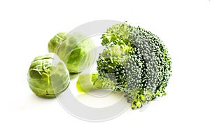Fresh brussels sprouts and broccoli on white background.
