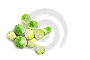 Fresh Brussels sprouts and leaves on white background