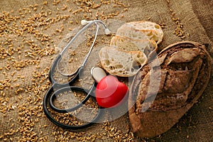 Fresh bun and sliced pieces of bread with wheat and stethoscope, the concept of a healthy lifestyle without gluten