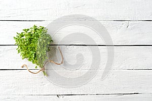 Fresh bunch of basil on vintage wooden table with copyspace.