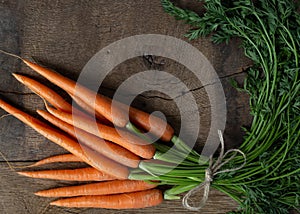 Fresh bunch of carrots on old wood background