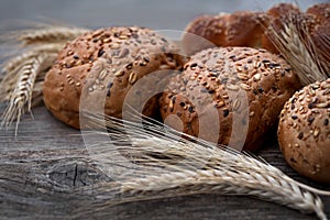 Fresh buns with whole grains on a wooden table