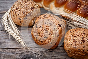 Fresh buns with whole grains on a wooden table