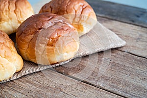 Fresh butter roll bread bun on gunny sack cloth on wooden table