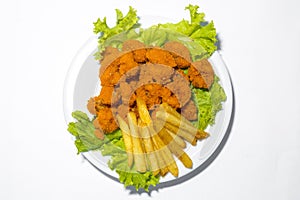 Fresh calamari with french fries in a plate. Healthy sea food squid fry, potato fries and lettuce meal on white background photo