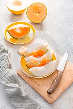 Fresh cantaloupe and lemon drop melon on cutting board - low calorie refreshment
