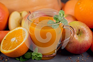 Fresh carrot, apple, pumpkin, orange, grapefruit on dark table.