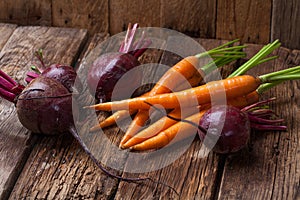 Fresh carrot, beet on a wooden rustic table.