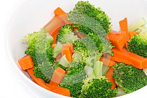 Fresh carrots and broccoli in a white bowl