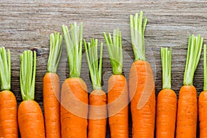 Fresh carrots bunch on rustic wooden background.