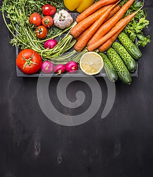 Fresh carrots cherry tomatoes, garlic, cucumber, lemon, pepper, radish, wooden spoon salt pepper colored, oil wooden rustic backgr