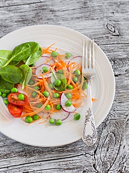 Fresh carrots, radishes, spinach and green peas salad. Healthy food.