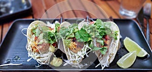 Fresh caught Mahi Mahi fish tacos with shredded cabbage, avocado, tomatillo salsa, vine-ripened tomatoes, and cilantro on corn