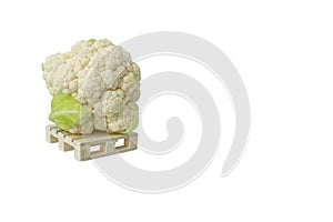 1 fresh cauliflower on wooden mini pallet isolated on white with large copy space.Head,inflorescence of botrytis caulie