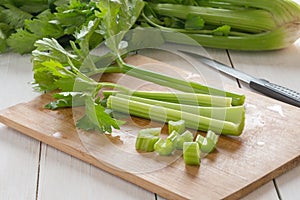 Fresh celery chopped on wooden cutting board