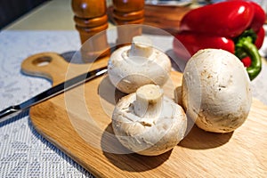 Fresh champignon mushrooms on a cutting board. Close-up. Vegetarian food