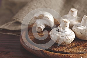 Fresh champignons mushrooms on wooden table