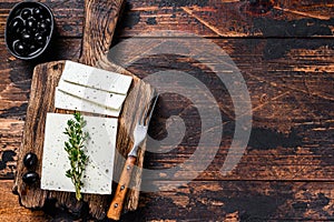 Fresh cheese feta with thyme and olives. Dark wooden background. Top view. Copy space