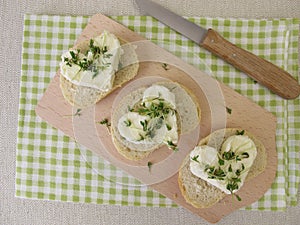 Fresh cheese hearts with cress sprouts on baguette