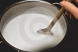 Fresh cheese making step by step, heating milk into a saucepan, homemade cottage cheese photo